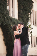 Fototapeta premium Happy wedding couple, groom, bride with pink dress hugging and smiling each other on the background walls in castle