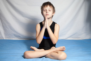 The young boy practices yoga