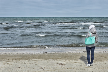 Young woman looking the sea from the beach