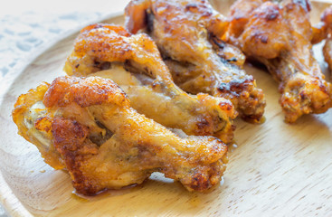 Fried chicken leg on wood plate