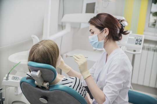 young woman doctor in a dental clinic. the dentist sits in the Cabinet beside the chair with the patient
