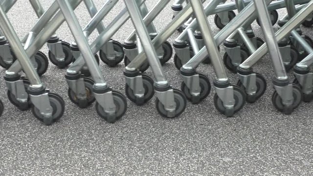 Retail store shopping carts or trolleys collected and pushed by man using robotic pusher or mover 