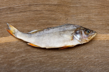 Salty dry river fish on a wooden impressive background.