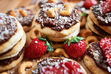 vegan homemade coconut cookies with strawberries and chocolate nut toping, close up