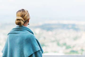 Back view of a woman with tied blond hair.