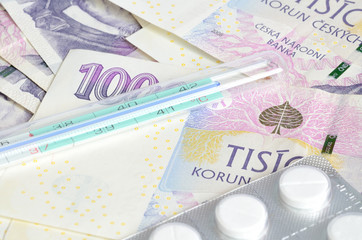 Thermometer, pills and czech banknotes money currency texture background