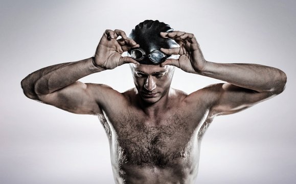 Composite image of swimmer holding goggles