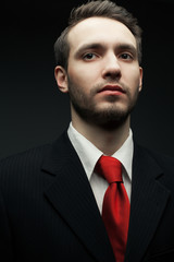 Portrait of a young handsome man (businessman) in black suit