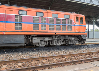 Fototapeta na wymiar Red orange train, Diesel locomotive, on railway station