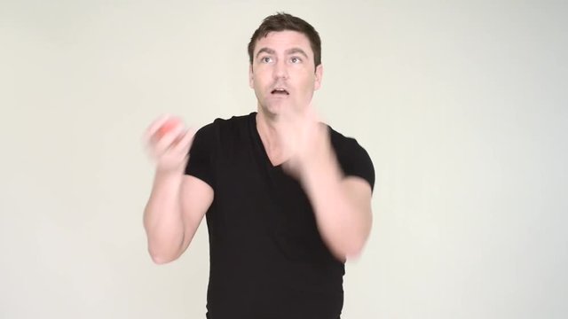 Man juggling balls and fails. He shows anger and frustration.