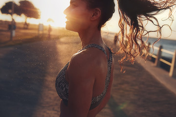 Fitness woman standing outdoors during evening - obrazy, fototapety, plakaty