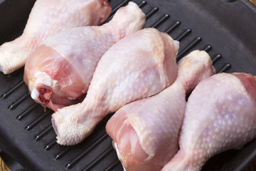 raw chicken drumstick in a pan