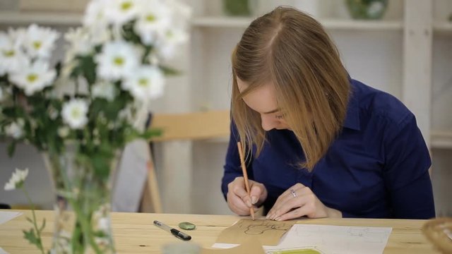 Young woman draws still life with pencil. Student learns to draft geometric shapes of object