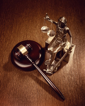 Statue of justice on old paper background with gavel, law concep