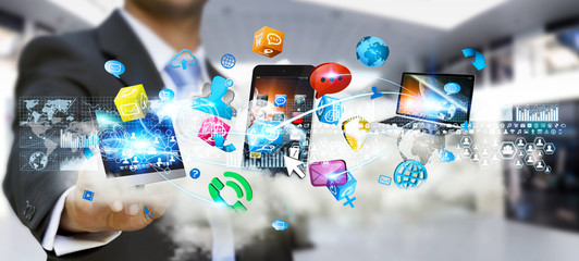 Businessman holding tech devices and icons applications over a c © sdecoret