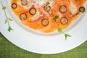 image of raw and fresh salmon sliced topped on ice in dish