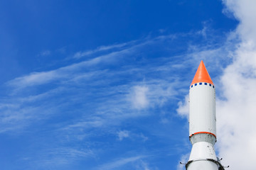 Rocket in the blue sky with clouds