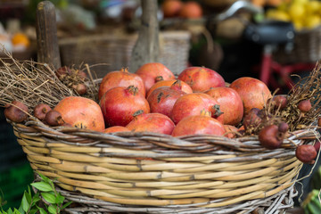 Group of fresh ripe pomegranate fruits in basket on display at local market