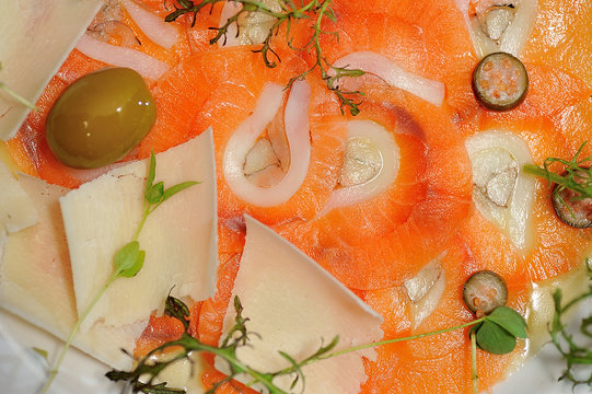 image of raw and fresh salmon sliced topped on ice in dish.