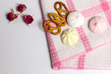 Cookies, murhmellows, dry roses on tablecloth, tasty photo