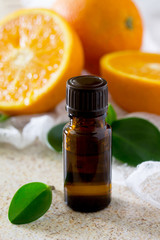 Bottle of orange essential oil for aromatherapy on a brown stone