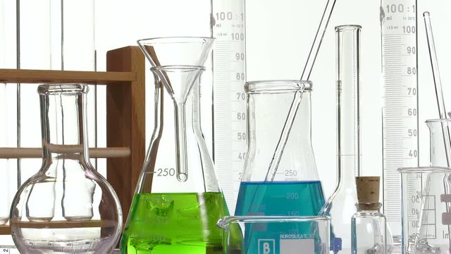 pouring green liquid in a Erlenmyer flask using a funnel