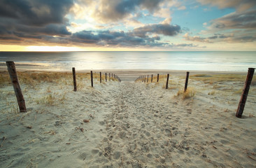 Fototapeta na wymiar sand path to North sea beach at sundown