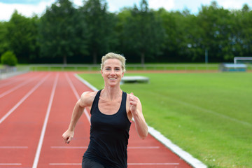 Obraz premium Healthy fit young woman running on a track