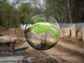 The ball flies with a plant on  background of  construction site and forest