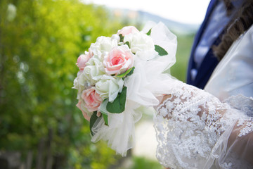 Wedding bouquet with white and pink flowers in bride's hands