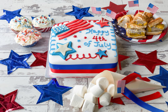 Independence Day cake with marshmallows, cupcakes and sausage rolls