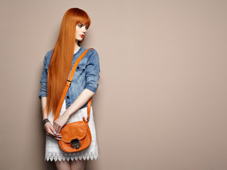 Fashion portrait of beautiful young woman with red hair. Girl in blouse and jeans. Jewelry and...