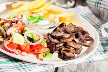 Grilled meat with French fries and fresh vegetables