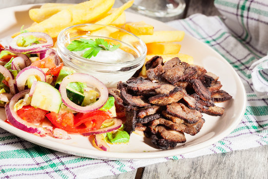 Grilled meat with French fries and fresh vegetables
