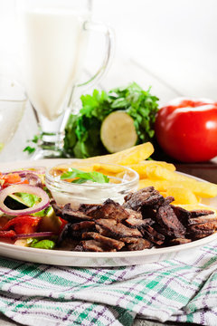 Grilled meat with French fries and fresh vegetables