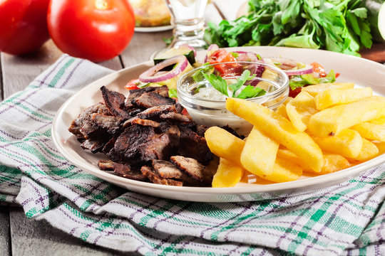 Grilled meat with French fries and fresh vegetables