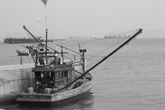 Old fishing boat in the sea in white and black tone