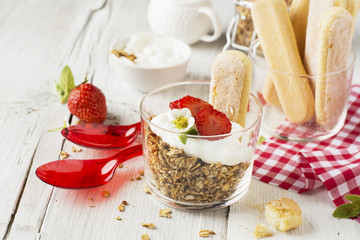strawberry yogurt with muesli on a old wooden background