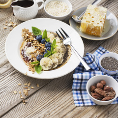 Healthy breakfast trend. Thin oat pancakes with banana, blueberries, goji berries, sesame and chia seeds