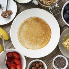 Oatmeal pancakes in a frying pan on wooden table