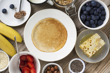 Oatmeal pancakes in a frying pan on wooden table