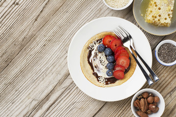 Oatmeal pancakes in a frying pan on wooden table