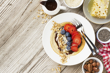Oatmeal pancakes in a frying pan on wooden table