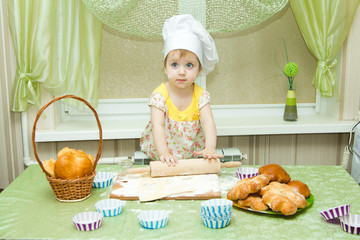 Cook - little girl on kitchen kneads dough, roll a rolling pin and bakes muffins and cakes, fun and hooligans