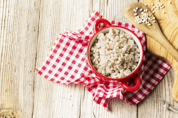 The red ceramic saucepan with white polka dots complete crumbly barley porridge