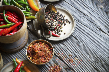 Hot peppers and spices on a dark wooden background
