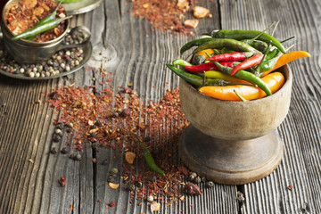 Hot peppers and spices on a dark wooden background