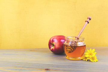Honey jar and apple on wooden rustic table. Jewish holiday Rosh Hashanah background
