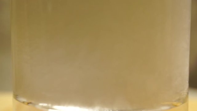 Slow motion macro video of pouring soda in a glass