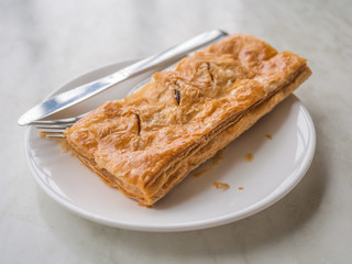 Tasty tuna patty on dish with knife and fork